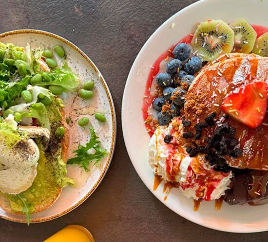 Plato de brunch con ensalada, fruta y tostada en Elzade Cafe