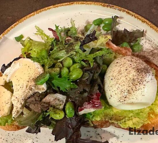 Brunch saludable con ensalada, huevo escalfado y aguacate en Elzade Cafe